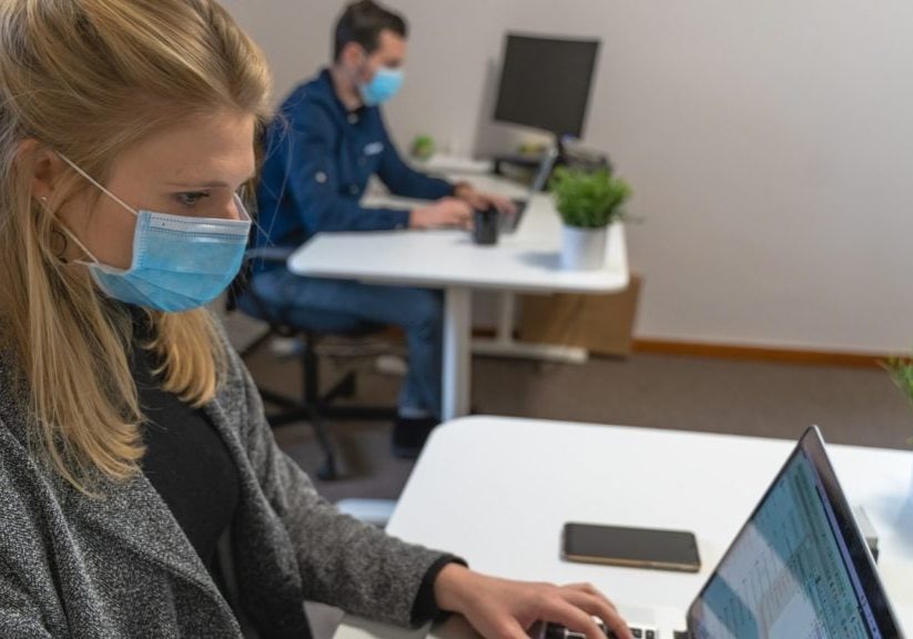 woman in black sweater holding white tablet computer