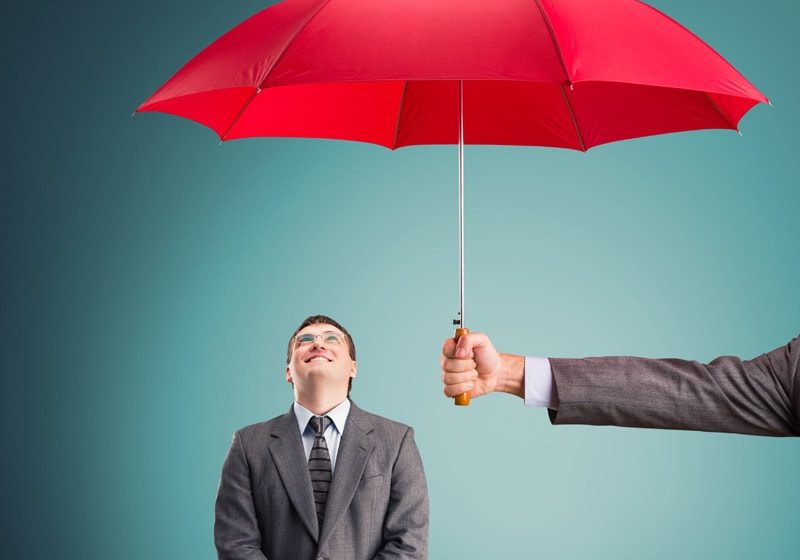 Cheerful businessman under an umbrella