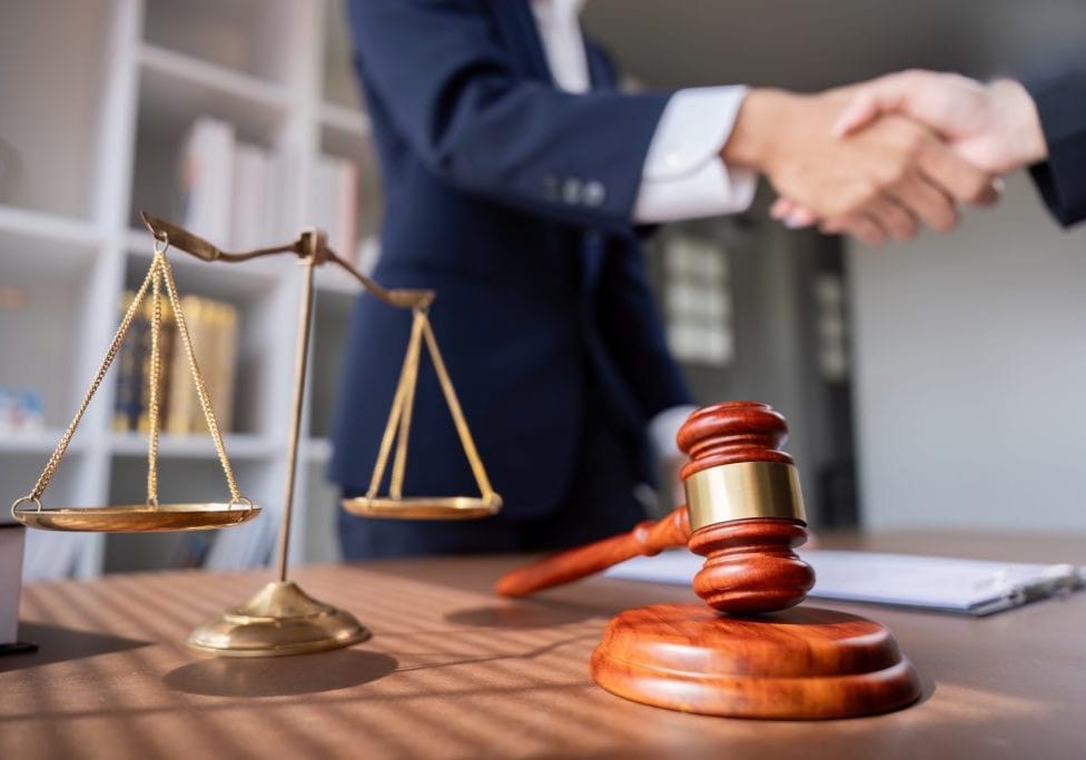 Professional,Lawyer,Handshake,In,Business,Meeting,With,Scales,Of,Justice